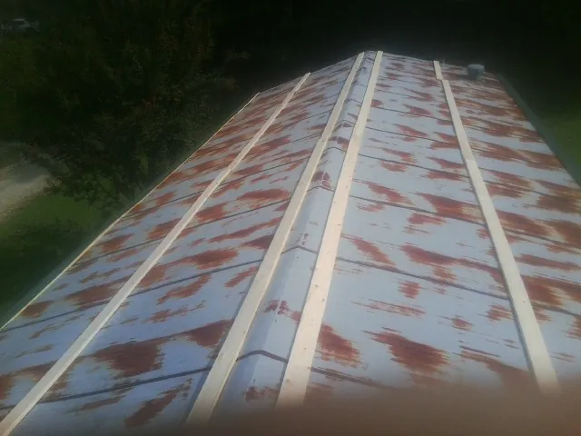 Rusted metal roof panels with new wood purlins before replacement — Storm Damage Roof Repair in Mansfield by Roofing Brothers